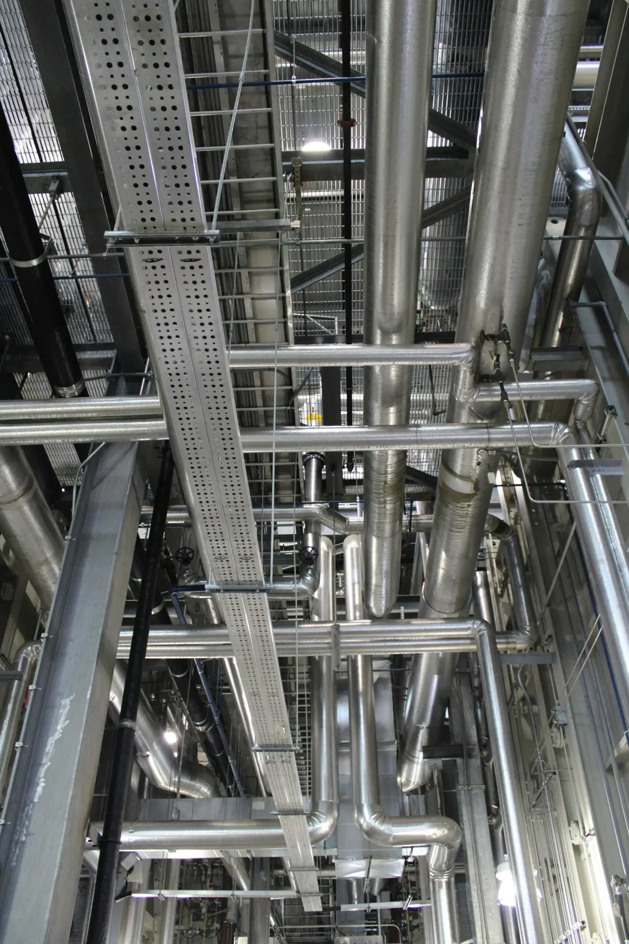 Etusivu Vertical shot of steel pipes and ventilation in an industrial setting.